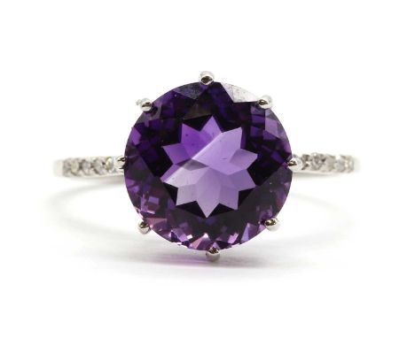 A 9ct white gold amethyst and diamond ring, with a round mixed cut amethyst, approximately 10mm, claw set to eight cut diamon