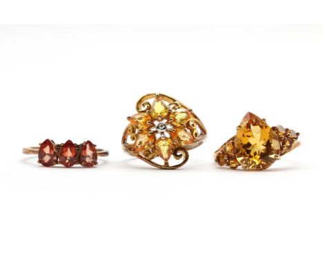 Three 9ct gold rings,comprising a diamond and yellow sapphire cluster ring, a citrine ring, and a three stone gem set ring, a