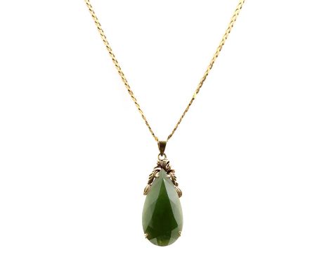 A gold nephrite jade pendant, the faceted pear shaped nephrite jade, claw set, to scroll surmount and articulated bale, suspe