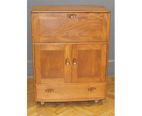 An Ercol blond elm drinks cabinet, with simply fitted fall front, over a pair of cupboard doors and single drawer with recess