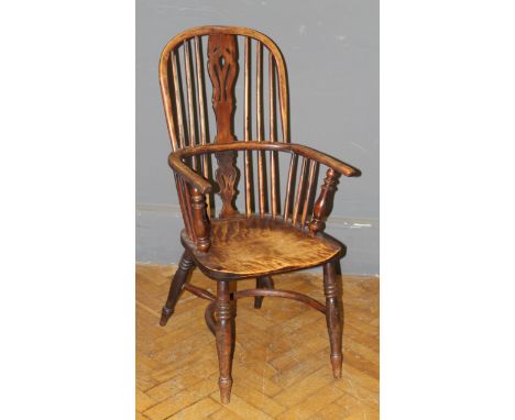 A 19th century yew and elm double hoop and stick back Windsor armchair, with saddle seat, raised on ring turned supports unit
