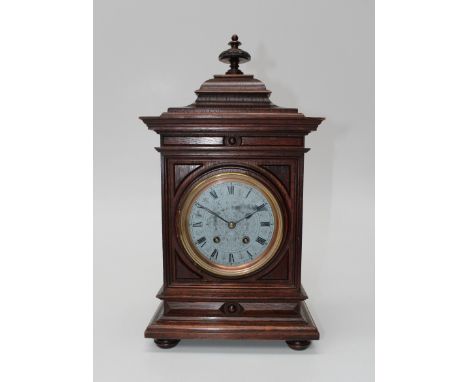 A late 19th century German oak mantle clock, the architectural case enclosing an eight day movement striking upon a gong, fac