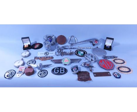 A mixed selection of car mascots and badges, including a Morris Minor hood ornament, a chromium plated Art Deco figure of a w