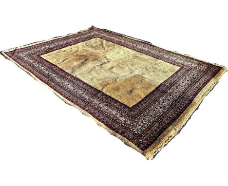 A Middle Eastern designed  wool carpet with central plain beige field and geometric borders, 300cm x 200cm approximately