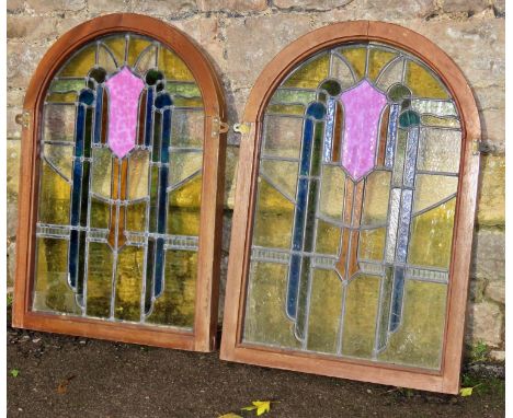 A pair of leaded light Art Deco style stained glass casement windows of arched form with hardwood frames 82 cm high x 56 cm w