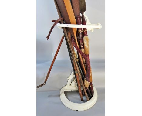 A Victorian white pained cast iron stick stand with four types of walking stick, two wooden African souvenir spears, a leathe