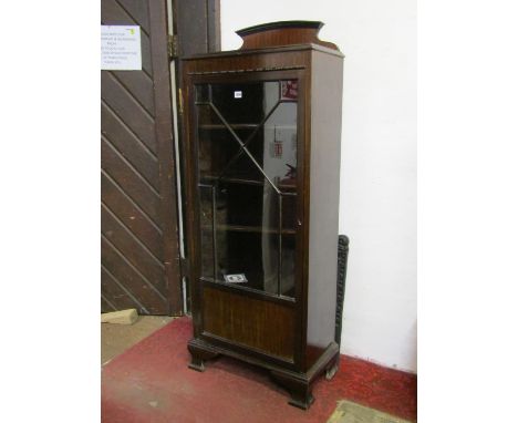 An Edwardian mahogany freestanding side cabinet enclosed by an astragal glazed panelled door revealing adjustable shelf to in