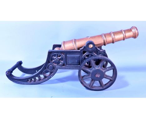 A model bronze field canon on a cast iron carriage and spoked wheels, 47cm long