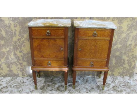 A pair of burr and figured walnut veneered bedside cupboards with loose veined marble tops, each fitted with two drawers flan