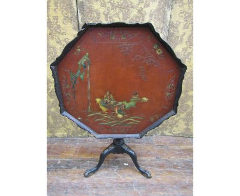 A 19th century Chinese lacquered occasional table of octagonal form, on turned pillar and tripod, with engraved chinoiserie d