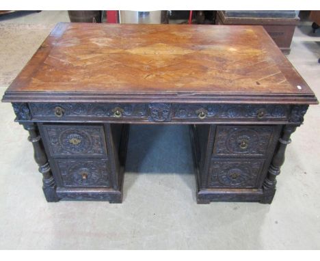 An antique oak kneehole twin pedestal desk with enclosed boarded back and carved detail, 73cm high x 134cm x 90cm