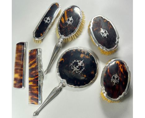 A silver and tortoiseshell dressing table set of 4 brushes, two combs and a hand mirror, Birmingham, 1929, Makers Mark Henry 