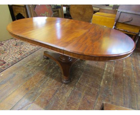 A Regency mahogany extending dining table raised on a turned column and tricorn base, the top 130cm diameter when closed, 190