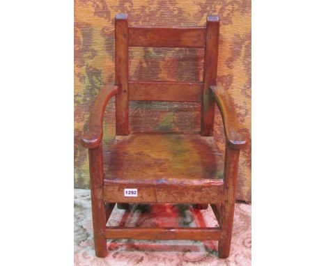 A stained pine bar back child’s size country made open armchair with solid seat 