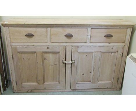 A narrow 19th century stripped pine dresser base with two panelled doors and three frieze drawers, 100cm high x 160cm wide x 