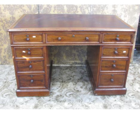 A good quality 19th century mahogany kneehole twin pedestal writing desk with inset leather top over an arrangement of nine d