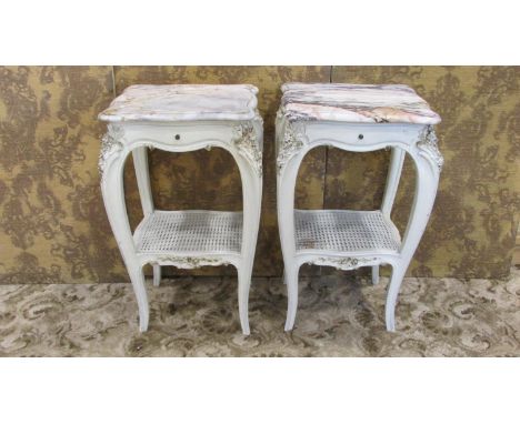 A pair of painted lamp/bedside tables with serpentine outline and decorative vein marble tops over frieze drawers and shaped 