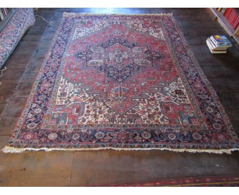 An old eastern wool carpet, the central lozenge shaped medallion upon a red field with abstract foliated detail, within furth