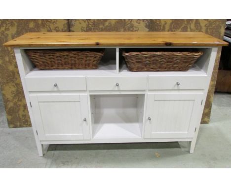 A contemporary partially painted kitchen dresser enclosed by an arrangement of cupboards, drawers and open compartments benea