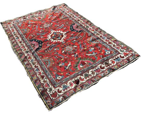 An Persian carpet with an all over field of flowers on a red ground, 205cm x 135cm approximately