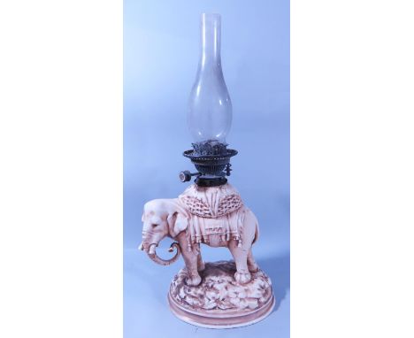 A china working elephant with docked tusks oil lamp base, lacks a shade, elephant 28cm x 23cm.