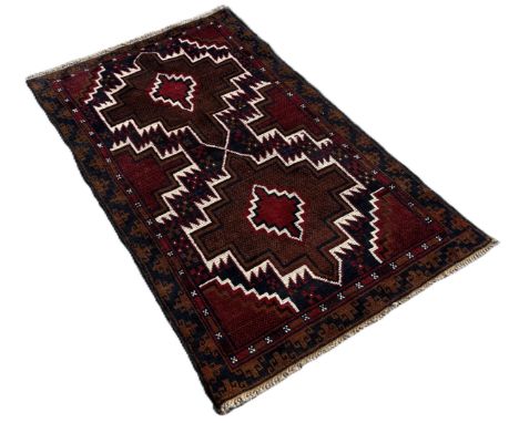 A Baluchi rug with red and blue zig-zag medallions 140cm x 86cm approximately 