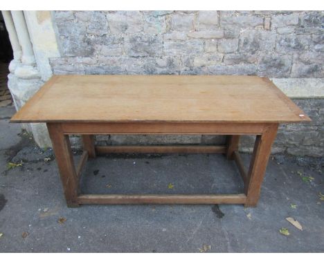 An Arts and Crafts oak dining table raised on four chamfered supports, the plank top with cleated ends, to seat six, 169cm lo