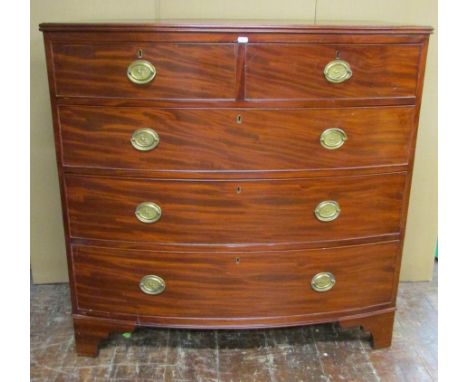 An early 19th century mahogany bow fronted chest of two short and three long drawers on bracket supports, with brass plate ha