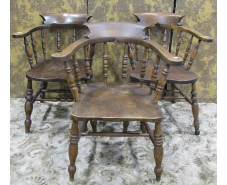 Three similar late 19th century Windsor smokers bow elbow chairs with turned spindle backs, saddle shaped seats and turned su