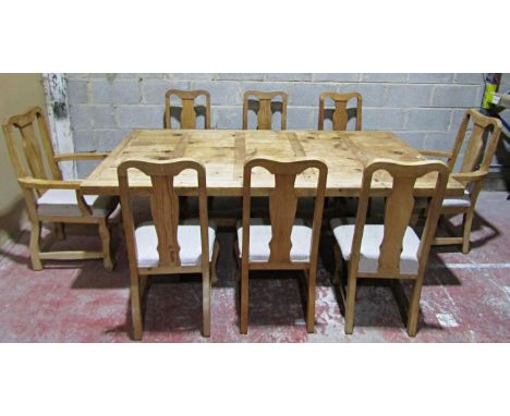 A substantial plank top pine kitchen table on shaped supports, together with a set of eight (6+2) dining chairs, the table 77