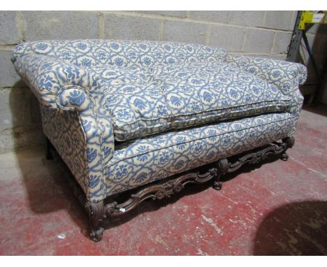 A 19th century two seat sofa with rolled arms, upholstered finish and deep feather filled loose seat cushion, cream ground wi