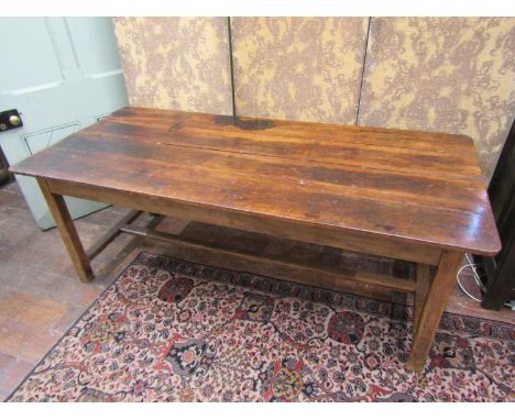 An antique farmhouse refectory table in mixed woods, the oak base with central stretcher supporting a fruitwood plank top, 76