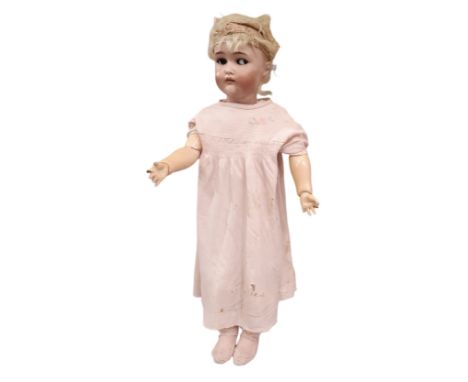 An early 20th century bisque head doll by Kammer &amp; Reinhardt with brown side glancing eyes, 4 teeth, pierced ears and joi