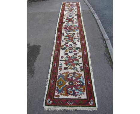 Indian wool runner, cream ground with floral detail within a running border, 370cm x 70