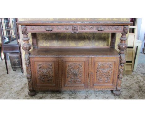 A Victorian carved oak buffet with lions mask, trailing fruit, scrolling acanthus and further detail, incorporating two friez