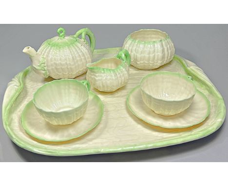 A Belleek second period porcelain tea set comprising tray, teapot, milk jug, sucrier, two cups and saucers, with black marks.