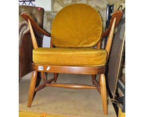 A vintage Ercol stained beechwood hoop and stick back open armchair with sprung seat and loose cushions 