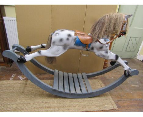 A traditional Victorian style rocking horse raised on boat shaped rockers, with leather harness and dapple grey painted finis