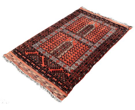 A Persian rug with mirrored geometric designs on a rusty red ground, 160cm x 55cm approximately