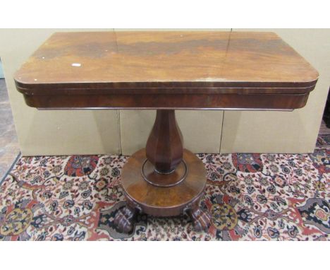 A Regency mahogany fold over top tea table on an octagonal vase shaped pillar with circular base and lions paw feet, 91cm wid