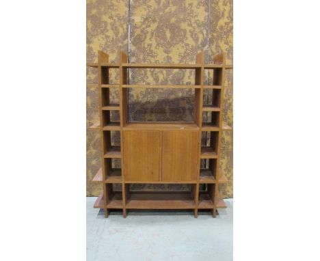 A light oak floorstanding shelving unit with segmented open shelves surrounding a cupboard, 128 cm high x 106 cm x 28 cm