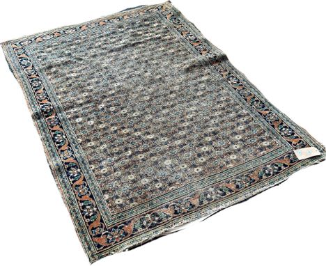 An old worn and faded Persian carpet with an all over floral pattern, 170cm x 120cm