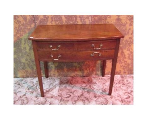 A Georgian mahogany bow fronted side table fitted with an arrangement of one long and two short drawers with swan neck handle