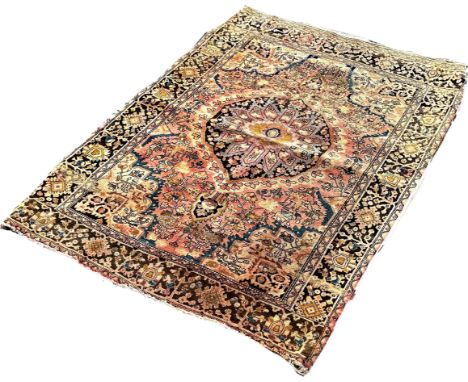 An old faded and worn Middle Eastern rug with a central rounded medallion on floral ground, 140cm x 105cm approximately