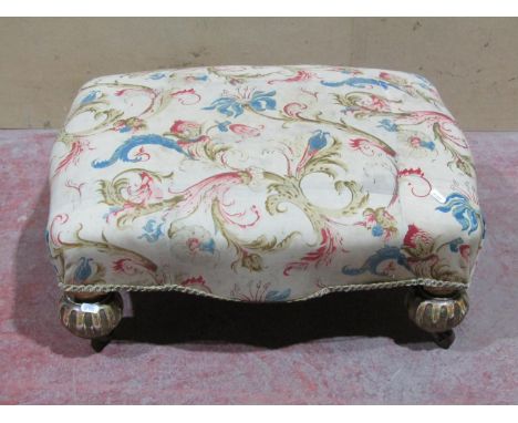 A 19th century centre footstool with serpentine with carved and gilded fluted bun feet, 30cm high x 70cm x 45cm