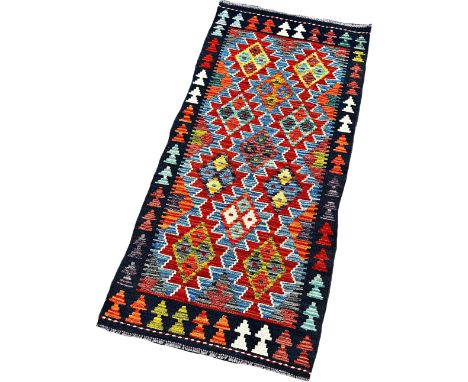 A Chobi Kilim runner with interlocking stepped lozenges 143cm x 67cm approximately 