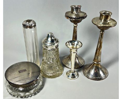 A pair of silver candlesticks, a silver posy vase, a sugar caster, and two glass vanity jars with silver caps and seven pins