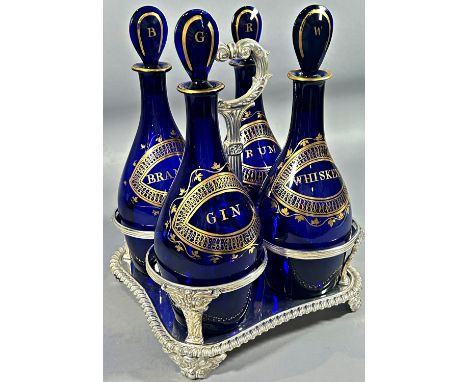 A set of four ‘Indian Club’ Bristol Blue Decanters,  (Brandy, Rum, Gin, and Whiskey), set in a Matthew Boulton’s silver plate