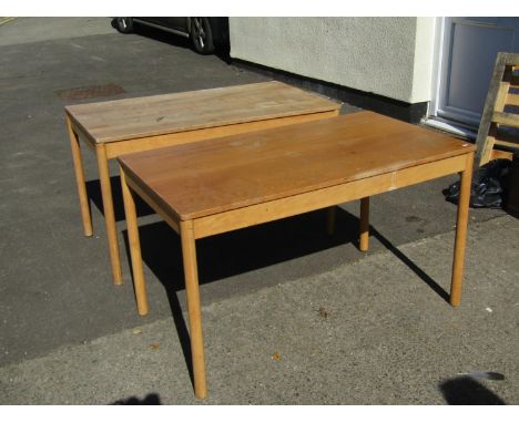 A pair of vintage Ercol tables, the elm tops raised on circular supports, 1222cm long x 69cm wide, together with set of three