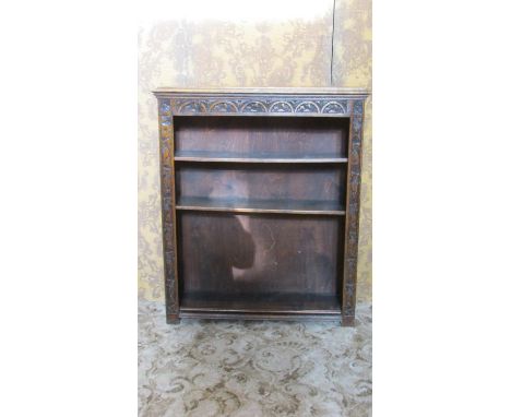 A Victorian oak floorstanding open bookcase, the front elevation with repeating carved foliate outline surrounding three adju